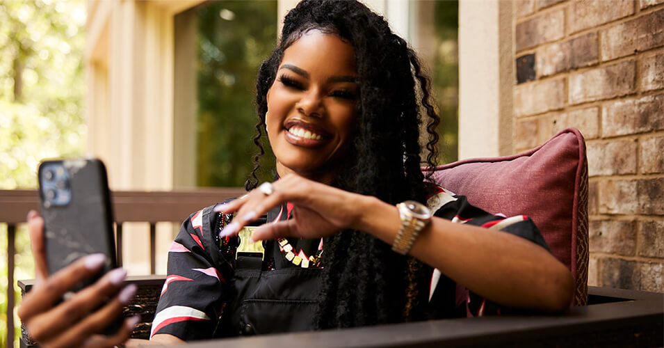 Teyana Taylor sitting outside on her phone